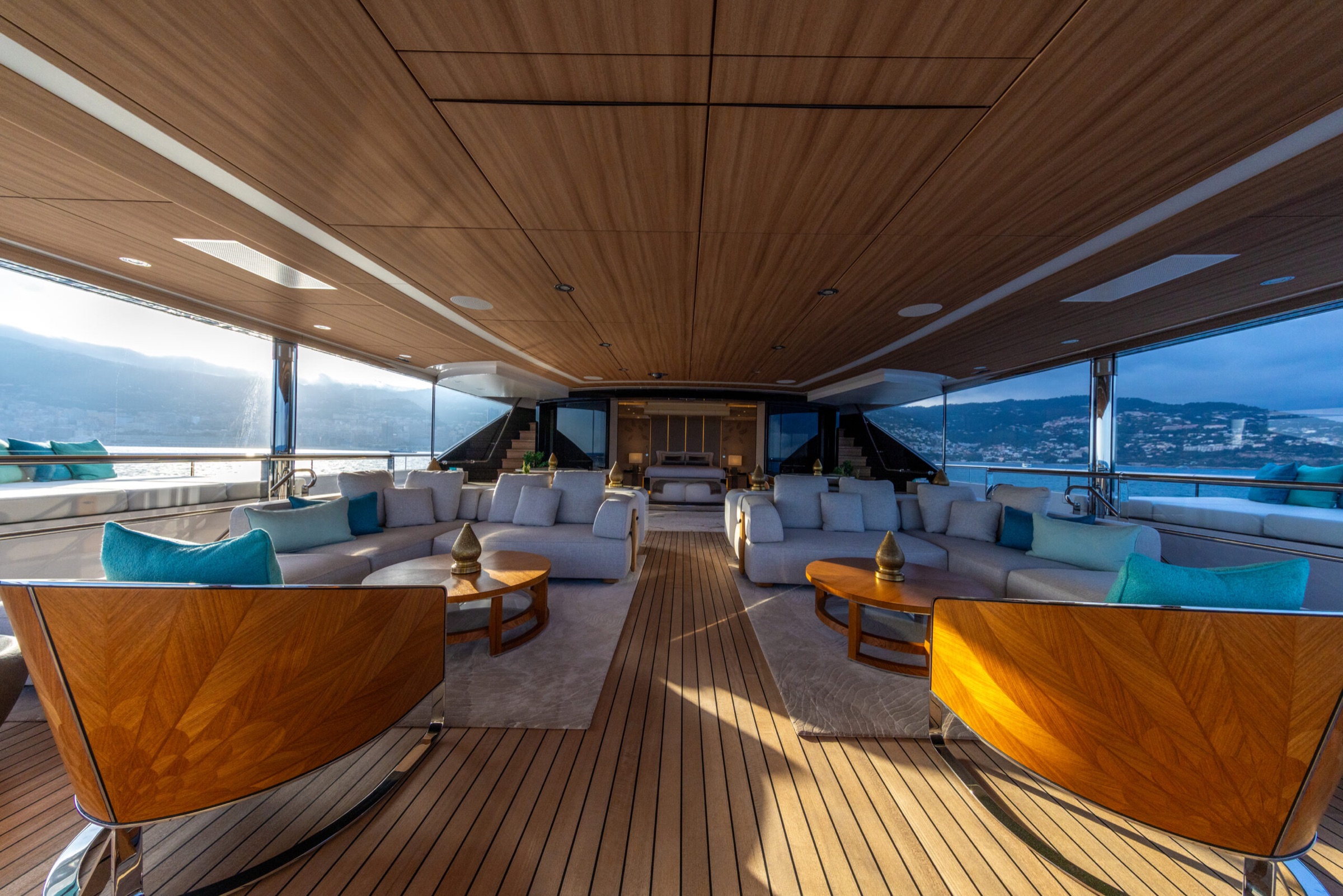 Glass-sided lounge with sofas on a teak deck